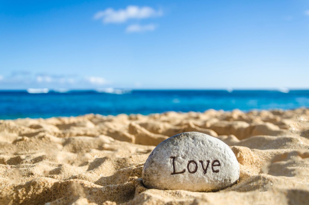 Sign love on the sandy beach near ocean in Hawaii Kauai - Valentine's day romantic concept